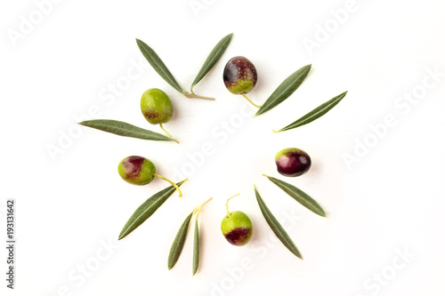 Olive leaves and olives forming frame on white with copyspace