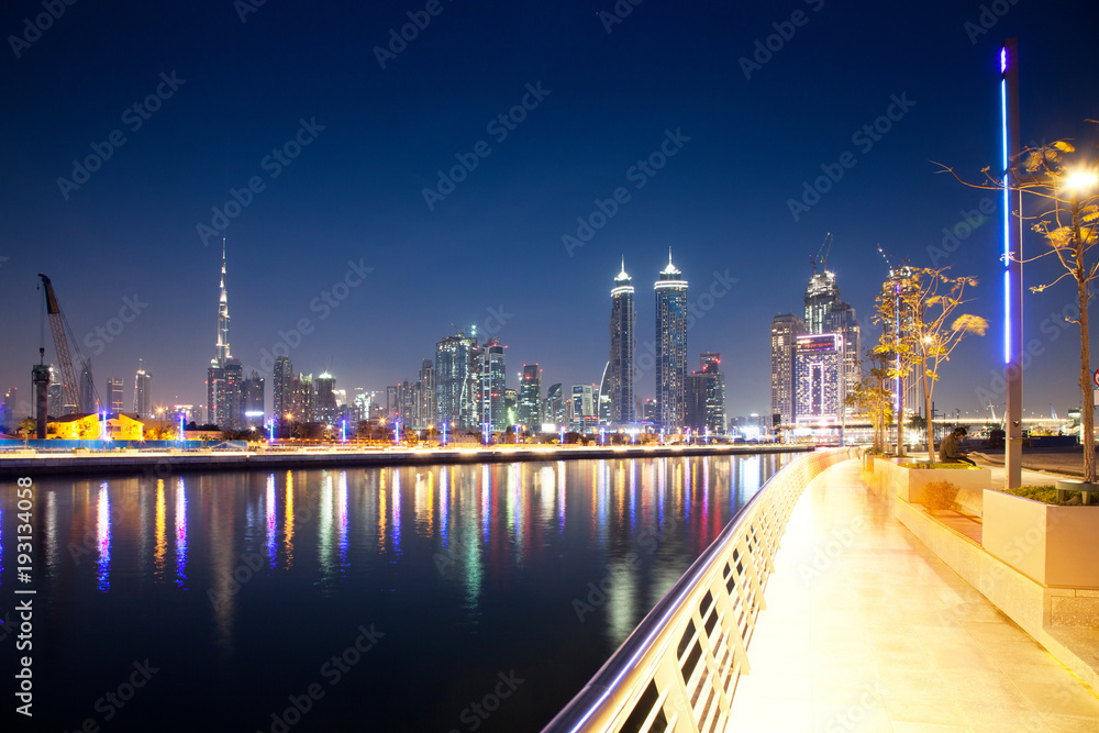 Obraz premium DUBAI, UAE - FEBRUARY 2018: Colorful sunset over Dubai Downtown skyscrapers and the newly built Tolerance bridge as viewed from the Dubai water canal.