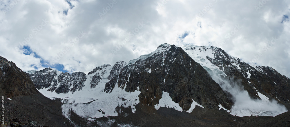 Panorama of valley with view to snow mountains and avalanche