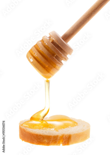 Honey is applied to the surface of bread. Isolated on a white background.
