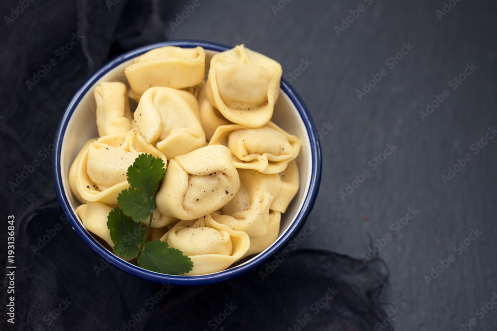 ravioli in beautiful bowl on black ceramic background ravioli in beautiful bowl on black ceramic background