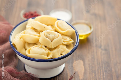 ravioli in beautiful bowl on wooden background