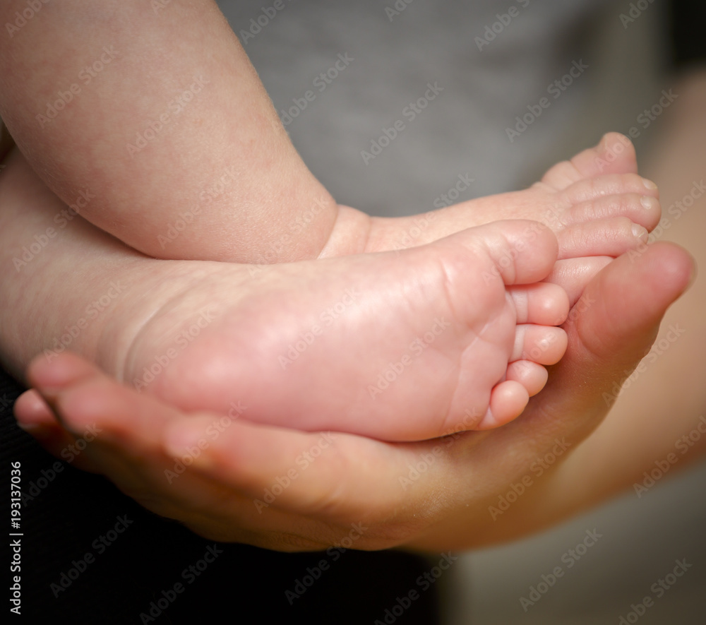 Feet of newborn baby in the hand of mother Feet of newborn baby in the hand of mother