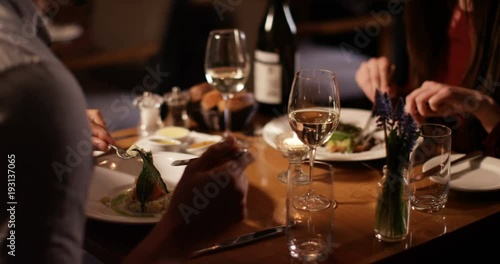 4K Unrecognizable couple on a date in restaurant chatting as they enjoy their meal. Slow motion