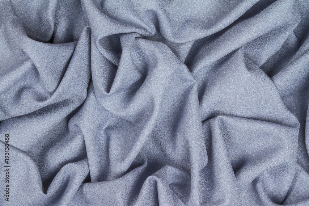 Blue woolen crumpled wrinkled fabric with waves, background crumpled tissue. Blue woolen crumpled wrinkled fabric with waves, background crumpled tissue.