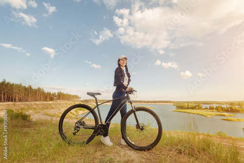Vacation time. Hipster woman traveling with bicycle on the forest relax time and holiday, color sport style selective and soft focus