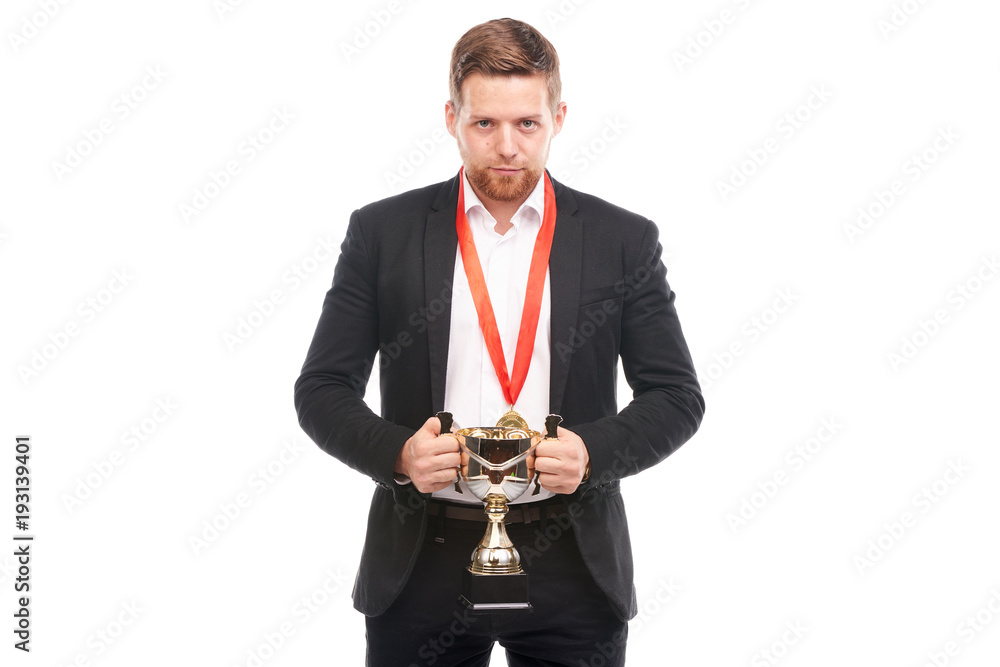 Portrait of confident young businessman wearing medal and holding trophy on white background Portrait of confident young businessman wearing medal and holding trophy on white background