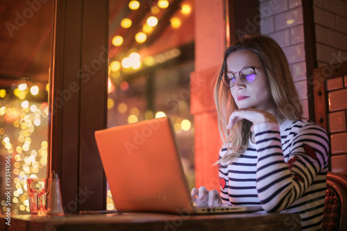 Girl sitting in a bar, using her laptop