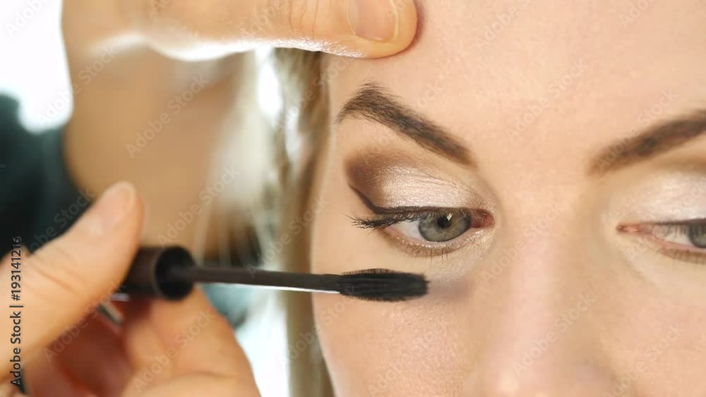 Close-up of professional make-up artist dyes the eyes of the model with a large brush. fashion industry cosmetics Close-up of professional make-up artist dyes the eyes of the model with a large brush. fashion industry cosmetics
