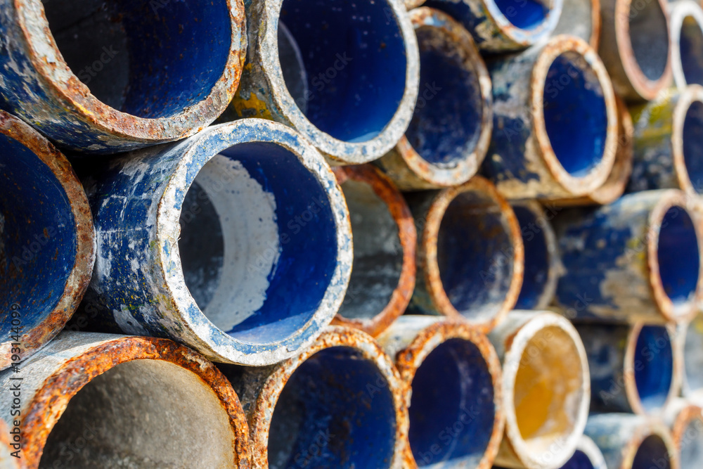 Mental scaffold pipe stack together on scaffold plank wood shelve with blue, green and yellow mark at the tip for build the temporary structure. Mental scaffold pipe stack together on scaffold plank wood shelve with blue, green and yellow mark at the tip for build the temporary structure.
