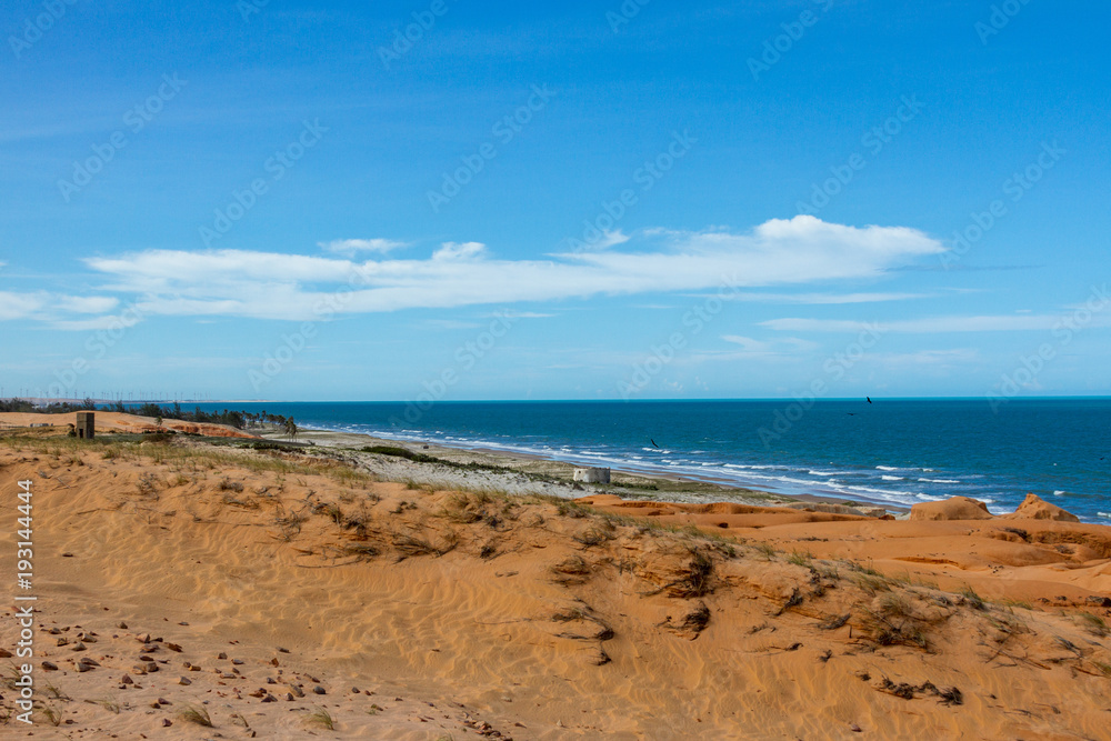 Canoa Quebrada, Brazil, January 2018 - View of red sanstone formation and a wind farm