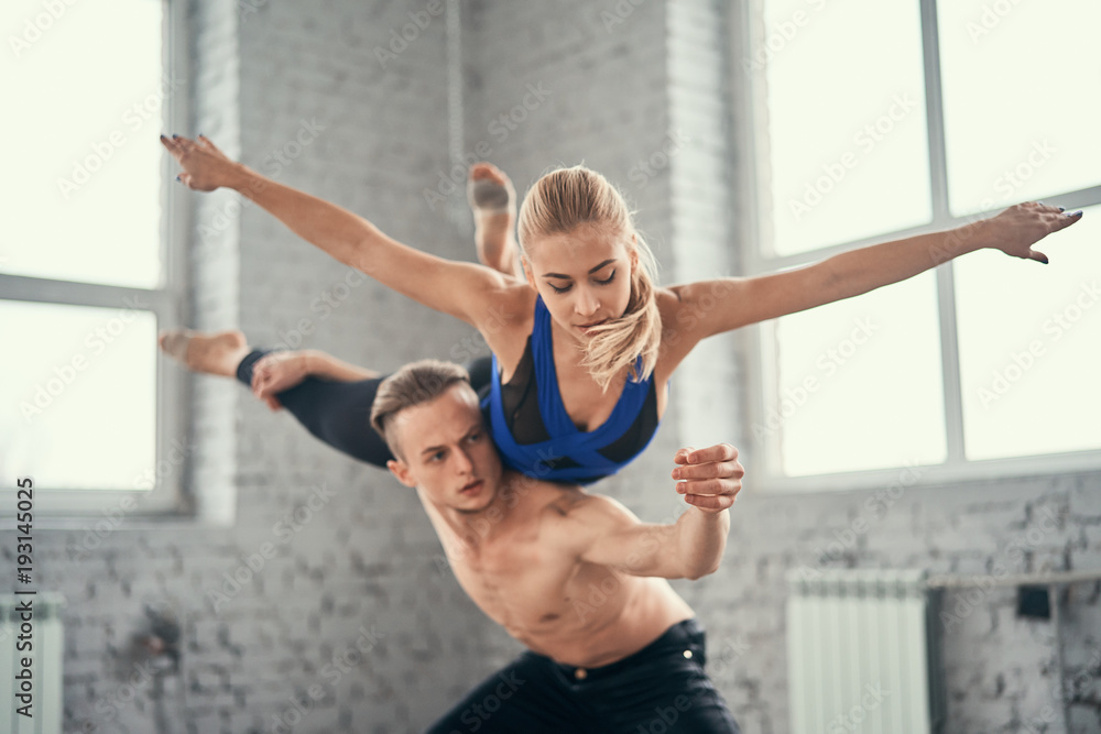 A young couple of dancers perform complex tricks. Couple of ballet dancers posing over urban background. A young couple of dancers perform complex tricks. Couple of ballet dancers posing over urban background.