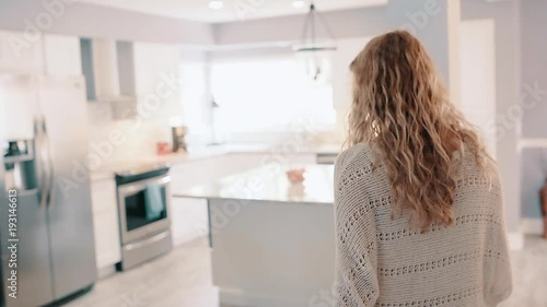 Woman Walking through Bright Clean Kitchen in Warm Cozy Sweater