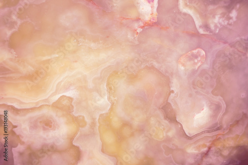 Lightened slices marble onyx. Horizontal image. Warm pink and yellow colors. Beautiful close up background