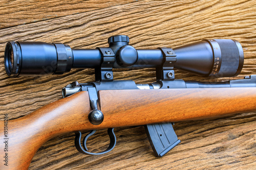 The riflescopes on old wooden background .
