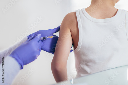 Doctor doing vaccine injection to a child, medicine, healthcare, pediatry and people concept photo