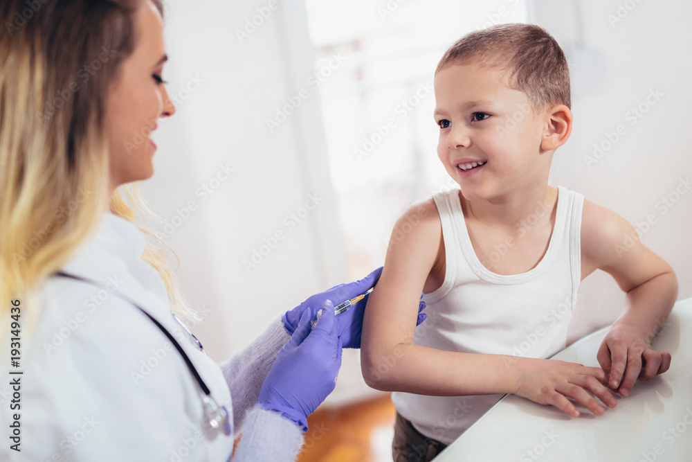 Fototapeta premium Doctor doing vaccine injection to a child, medicine, healthcare, pediatry and people concept