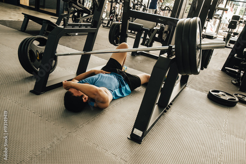 Tired man taking a workout rest. Male athlete suffering a headache or dizziness. Unmotivation in sport and tiredness concept. 