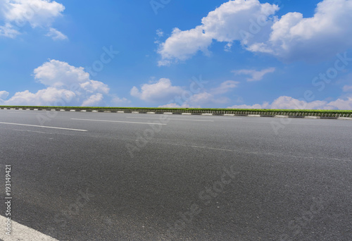 Asphalt pavements and square floor tiles under the blue sky and white clouds © 昊 周
