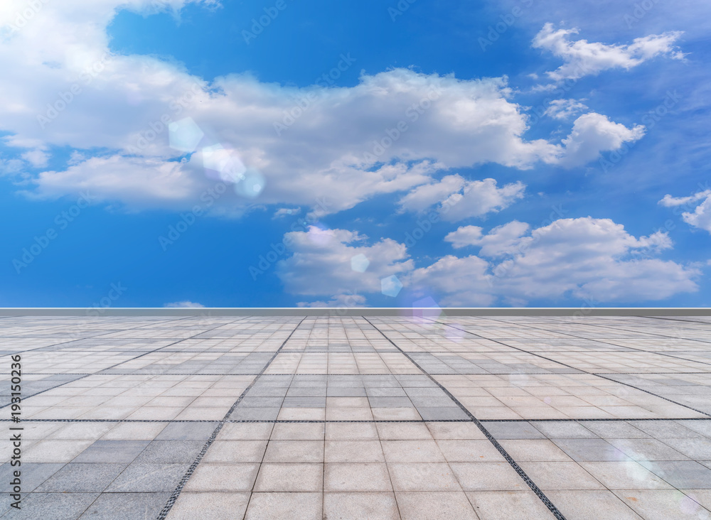 Asphalt pavements and square floor tiles under the blue sky and white clouds