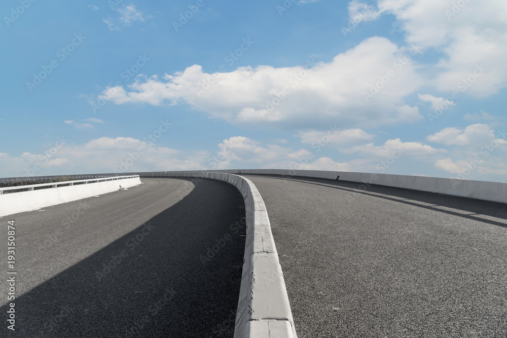 Asphalt pavements and square floor tiles under the blue sky and white clouds Asphalt pavements and square floor tiles under the blue sky and white clouds