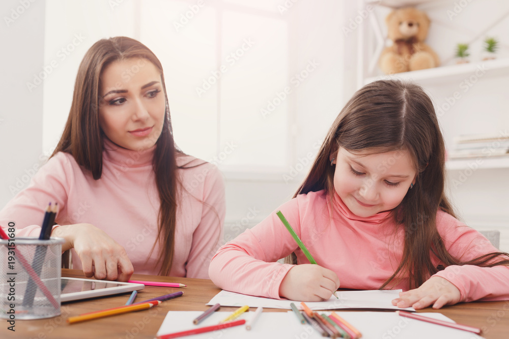 Mother helping her daughter with the homework. Mother helping her daughter with the homework.