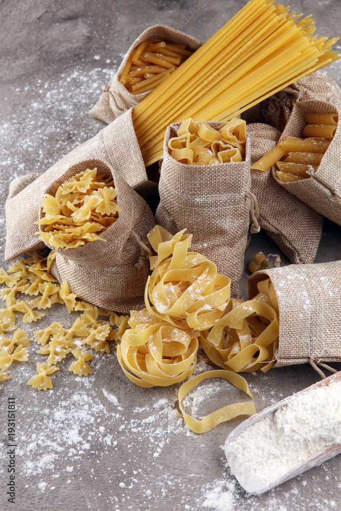 Fototapeta premium Various mix of pasta on grey rustic background. Diet and food concept.