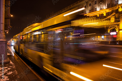 Blurred bus traffic on the avenue at night in winter