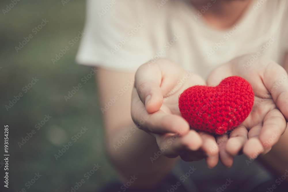 Sharing Love and Heart red color on women hand in valentine's day vintage color tone Sharing Love and Heart red color on women hand in valentine's day vintage color tone