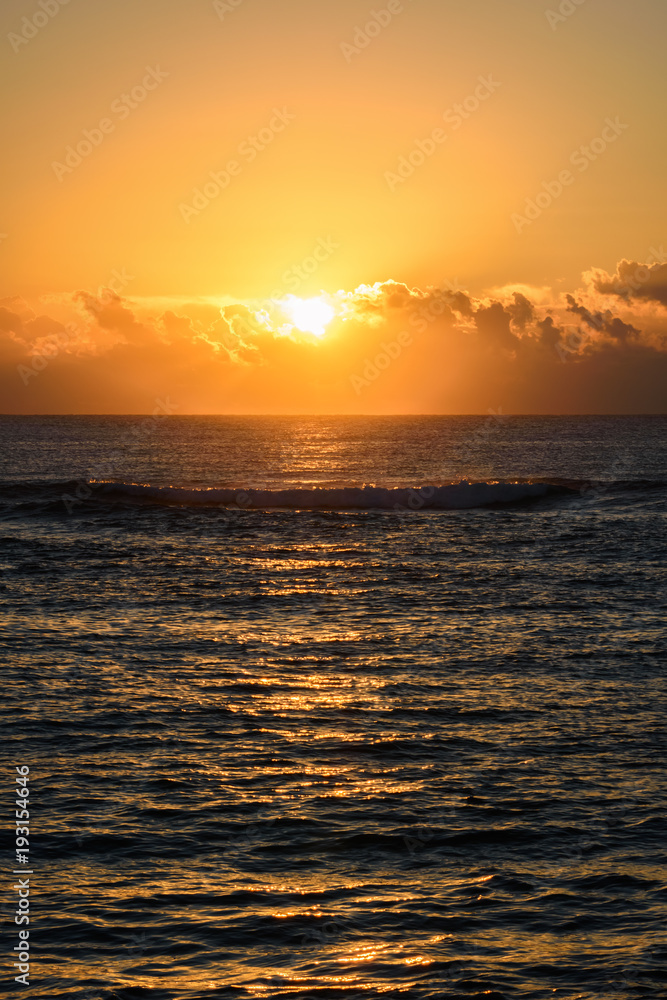 Golden sunrise or sunset over the sea. Vertical layout.