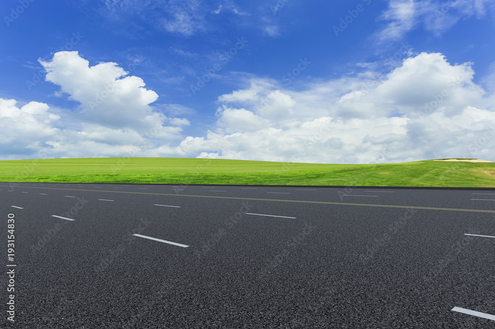 Asphalt pavements and prairies under the blue sky and white clouds