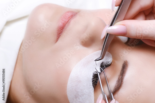 Eyelash Extension Procedure. Woman Eye with Long Eyelashes. Lashes, close up, selected focus.