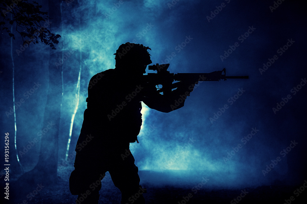 Black silhouette of soldier in the smoke moving in battle operation. Back light, cropped, toned and colorized Black silhouette of soldier in the smoke moving in battle operation. Back light, cropped, toned and colorized