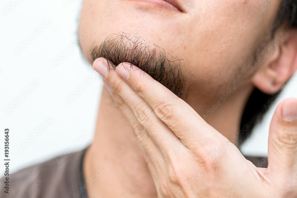 Closeup men beard with hand touching black hair at chin Closeup men beard with hand touching black hair at chin
