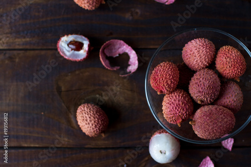 Raw organic lychee fruit on dark rustic wooden background