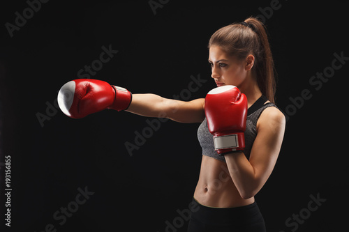 Side view of a gorgeous young woman with boxing gloves