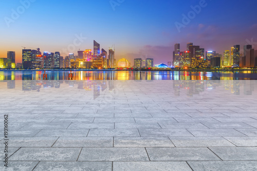 View of the skyline of Hangzhou urban architectural landscape from square floor tiles and empty asphalt pavement © 昊 周