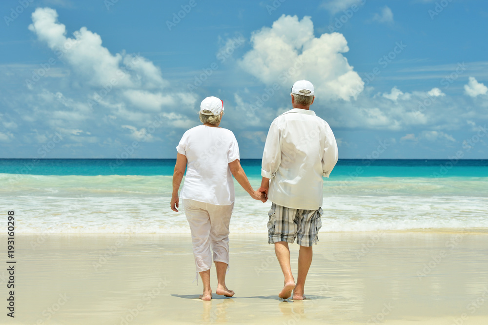 elderly couple running on beach elderly couple running on beach