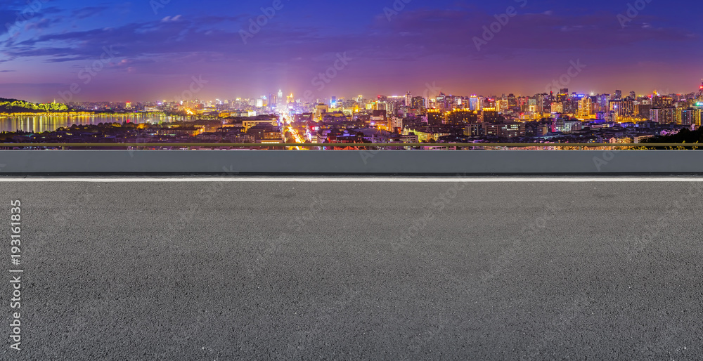 View of the skyline of Hangzhou urban architectural landscape from square floor tiles and empty asphalt pavement View of the skyline of Hangzhou urban architectural landscape from square floor tiles and empty asphalt pavement