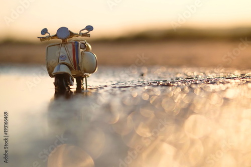 Modell Motorroller vor romantischem Sonnenuntergang mit Lensflares photo