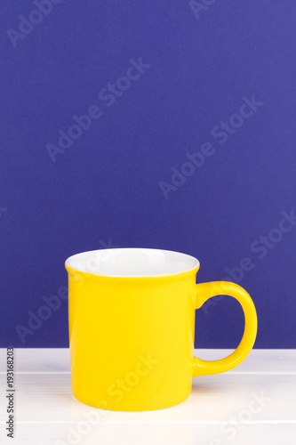 yellow cup with copy space purple background
