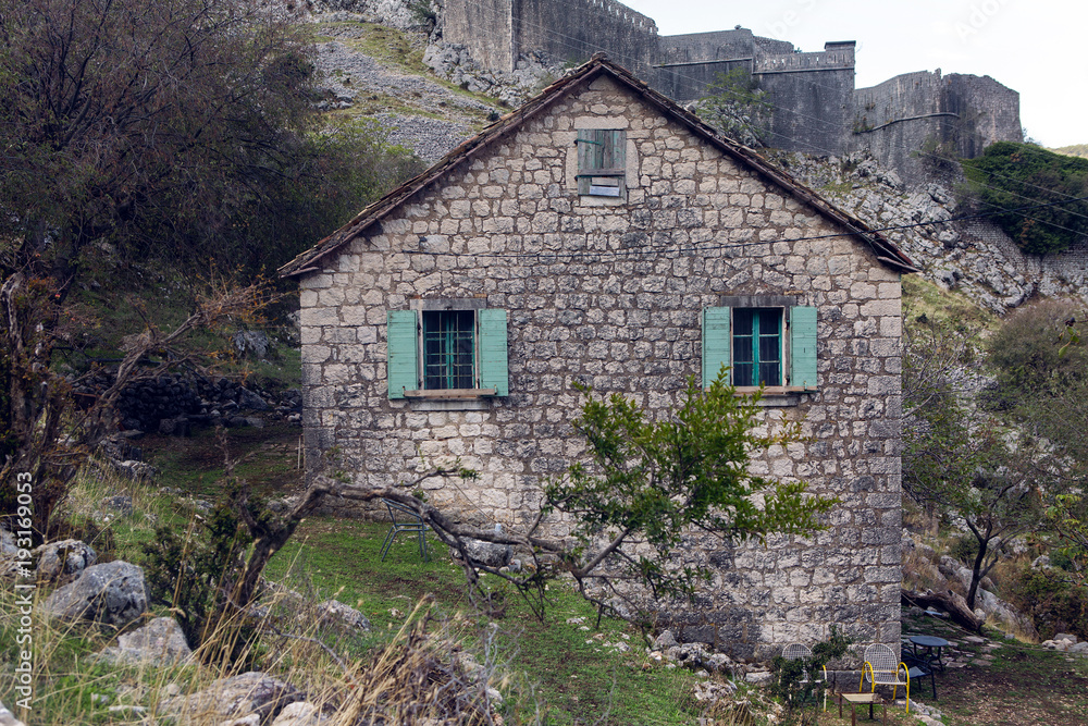 old stone house in the mountains with green Windows with fortress old stone house in the mountains with green Windows with fortress