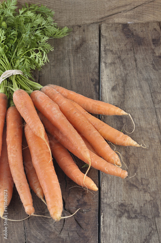close on bunch of fresh carrots on rustic wooden  background 