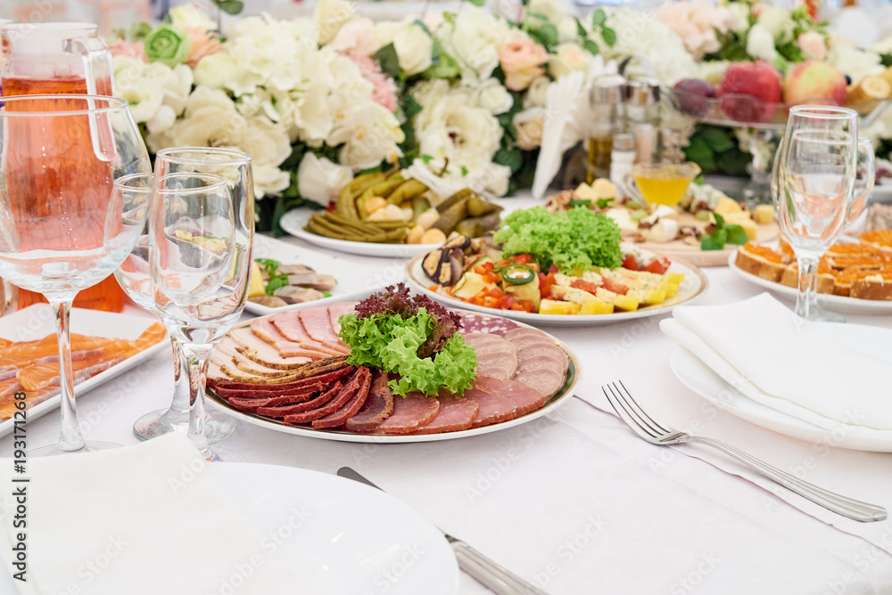 Cold meat plate on celebratory dinner table, copy space. Meat platter with selection on wedding banquet