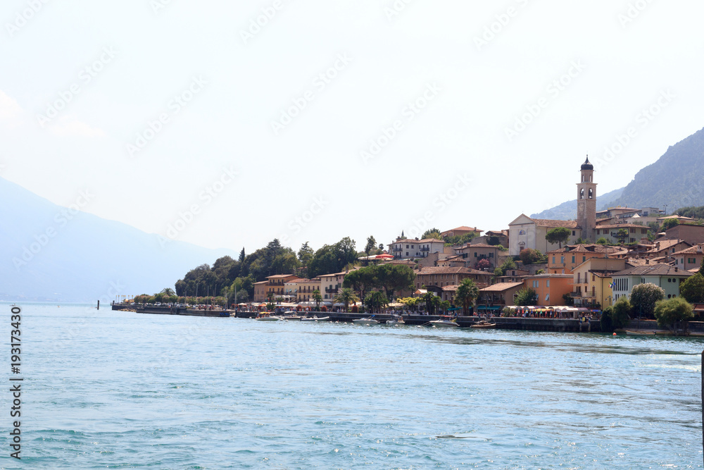 Townscape panorama of lakeside village Limone sul garda with boats and church at Lake Garda, Italy