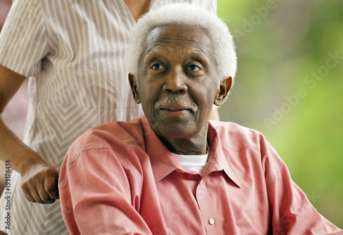 Senior man being pushed in a wheel chair.