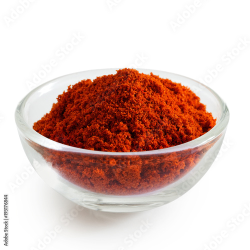 Paprika in glass bowl isolated on white.