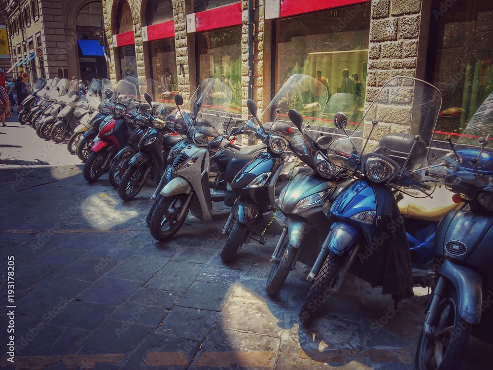 Fototapeta premium Rząd zaparkowanych skuterów przy ulicy