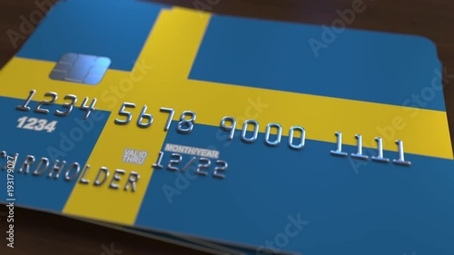 Plastic bank card featuring flag of Sweden. National banking system related animation photo