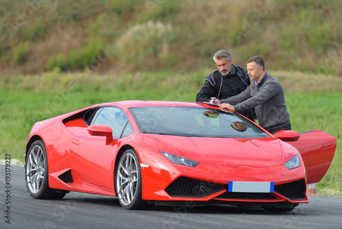 Obraz na plátně two men stood by sports car